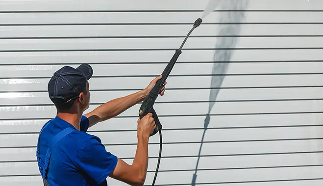man washing siding